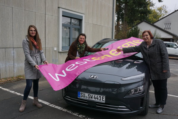 V.l. Alina Werres (Werksstudentin), Lydia Bauer und Petra Kalkbrenner stehen vor dem neuen E-Auto der Gemeinde Swisttal.