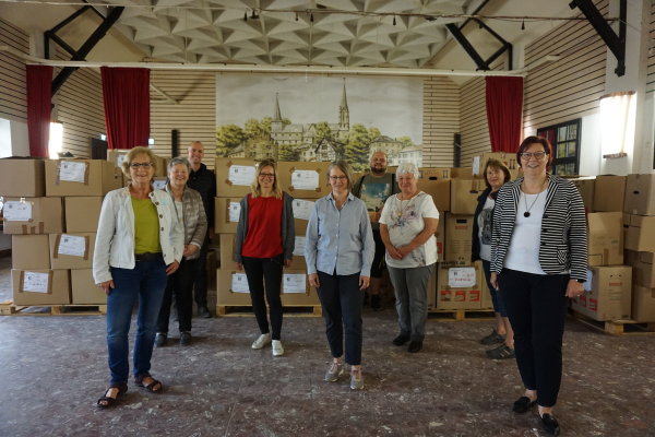 Inge Eichen-Nosbisch, Brigitte Haselwanter, Beigeordneter Tobias Weingartz, Julia Krause, Claudia Göbbels, Stefan Dilly, Eliasbeth Kümpel, Gertrud Klein und Bürgermeisterin Petra Kalkbrennerstehen in dem Info-Punkt in Odendorf.