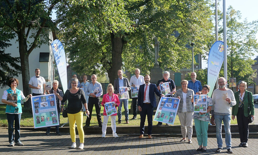 Auf dem Bild sind eine Vielzahl von Personen zu sehen, die mit vorgehaltenen Plakaten Werbung für die Lesetage machen