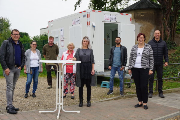 Stefan Mayer, Fina Schwenecke, Werner Kreuzberg, Waldtraud Piontek, Anja Fritzsche, Jakob Dück, Bürgermeisterin Petra Kalkbrenner, Beigeordneter Tobias Weingartz stehen vor dem Iinfopoint in Heimerzheim. 