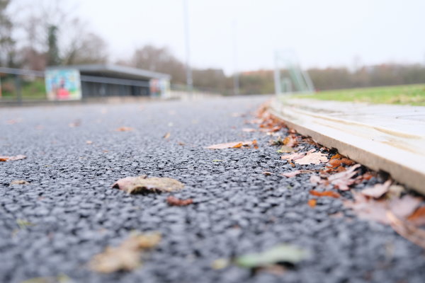 Das dargestellte Bild wurde auf Bodenhöhe erstellt. Zu sehen ist die unfertige Laufbahn sowie die Rasenfläche. Beim Wechsel von der Laufbahn zur Rasenfläche ist eine etwa zwei Centimeter hochstehende Kante.